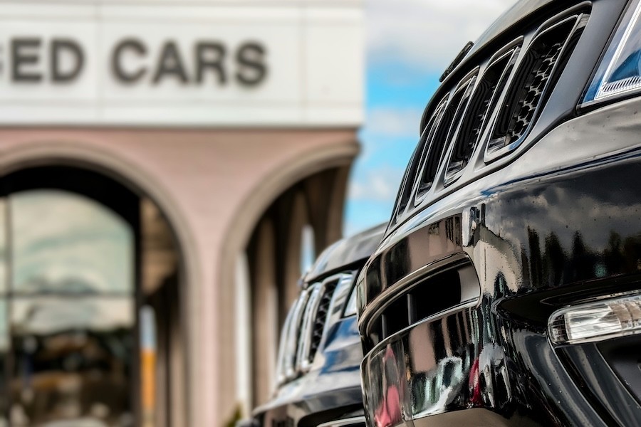 A row of cars outside a used car dealership.