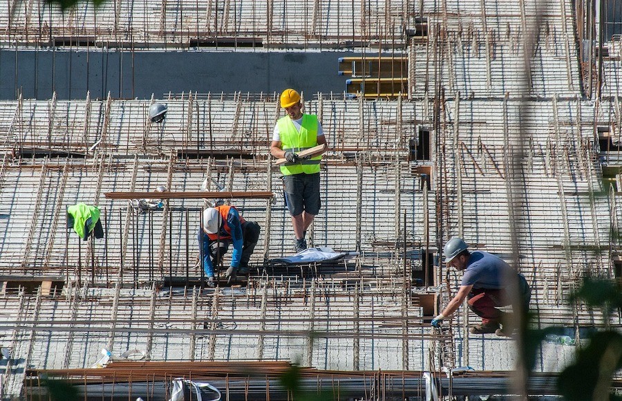A group of workers working on rebar on a construction site.