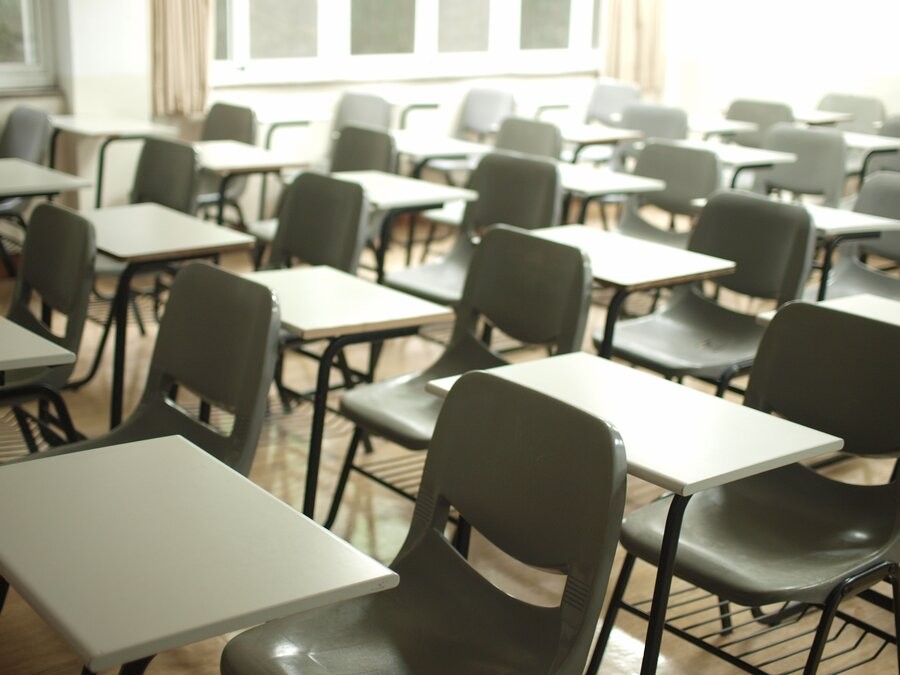 Classroom with empty desks and chairs, easily viewed via school camera systems.