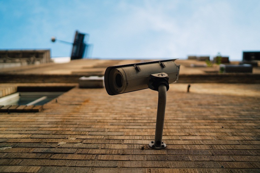 A security camera mounted to a brick building.