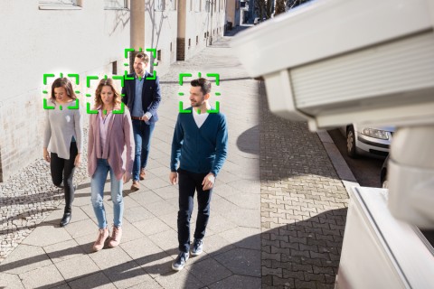 A security camera using face recognition on a group of people passing by. 
